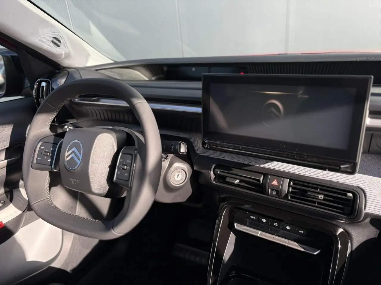 Vue intérieure côté conducteur du tableau de bord noir et gris du Citroën C3 Aircross Hybrid avec écran tactile central.