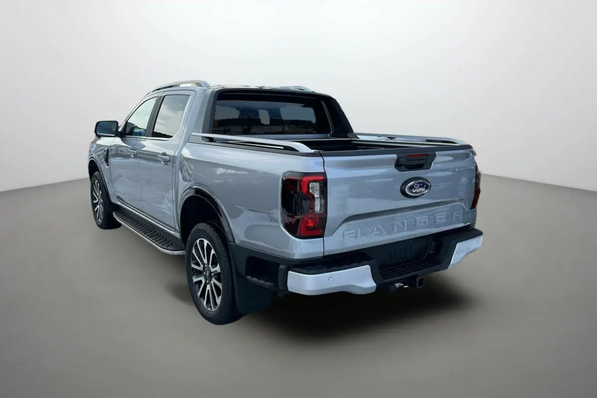 Ford Ranger gris iconic en 3/4 arrière droit, avec rideau de benne et jantes alu 20 pouces visibles.