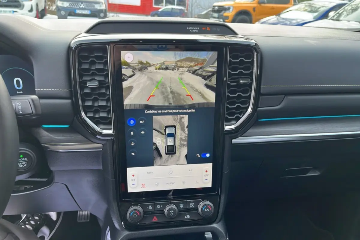 Vue intérieure centrée sur l’écran tactile vertical du Ford Ranger gris iconic, affichant la caméra 360° et les commandes climatisation.