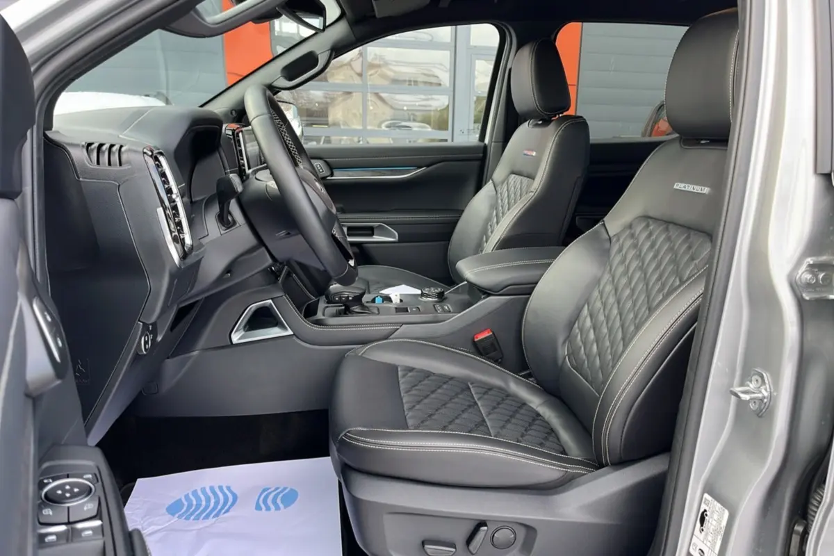 Vue intérieure côté gauche du Ford Ranger 2026 gris iconic, sièges cuir Platinum avec surpiqûres et volant multifonctions.