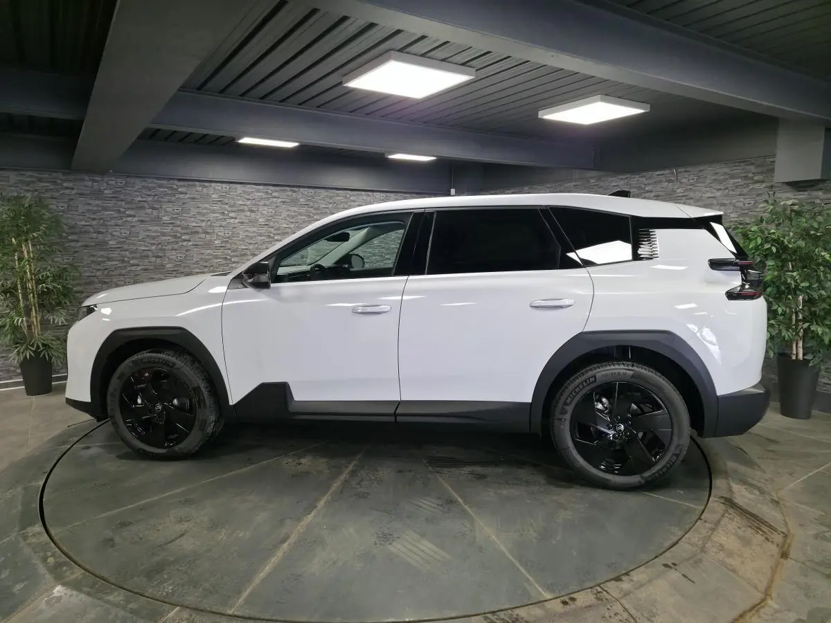 Vue latérale droite du Citroën C5 Aircross blanc avec jantes noires et détails noirs contrastants en intérieur.