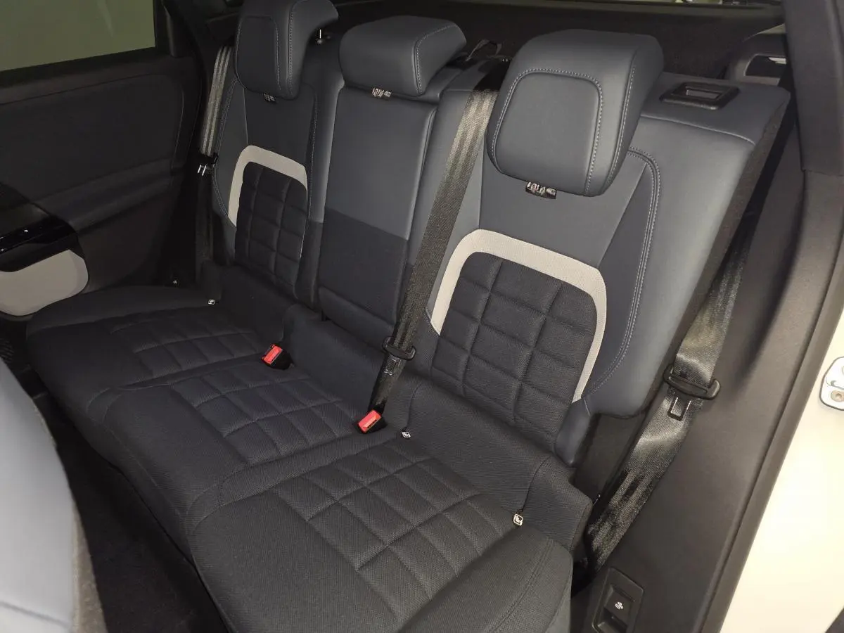 Vue intérieure arrière du Citroën C5 Aircross 2026, sièges tissu bleu avec inserts clairs et ceintures noires.