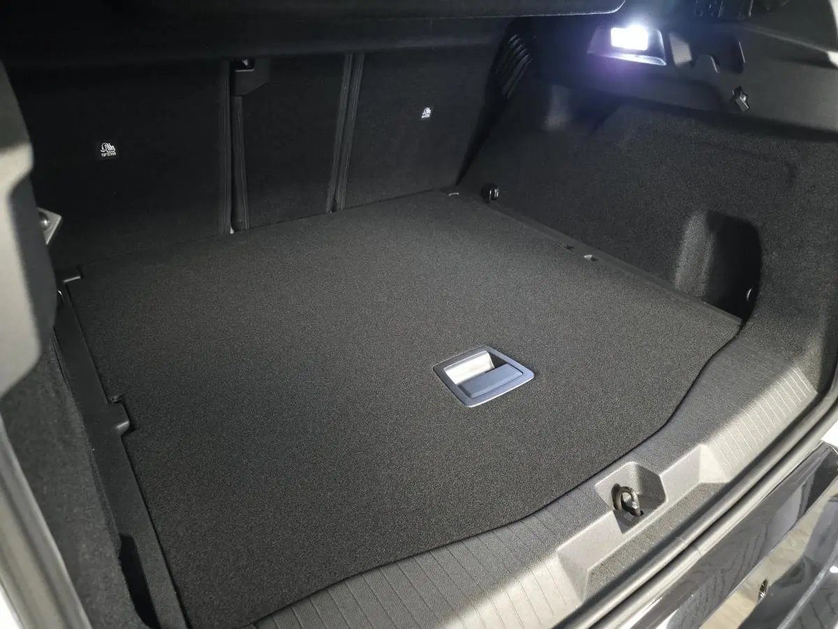 Coffre ouvert vu de l'arrière du Citroën C5 Aircross blanc, montrant un espace de chargement plat et noir.