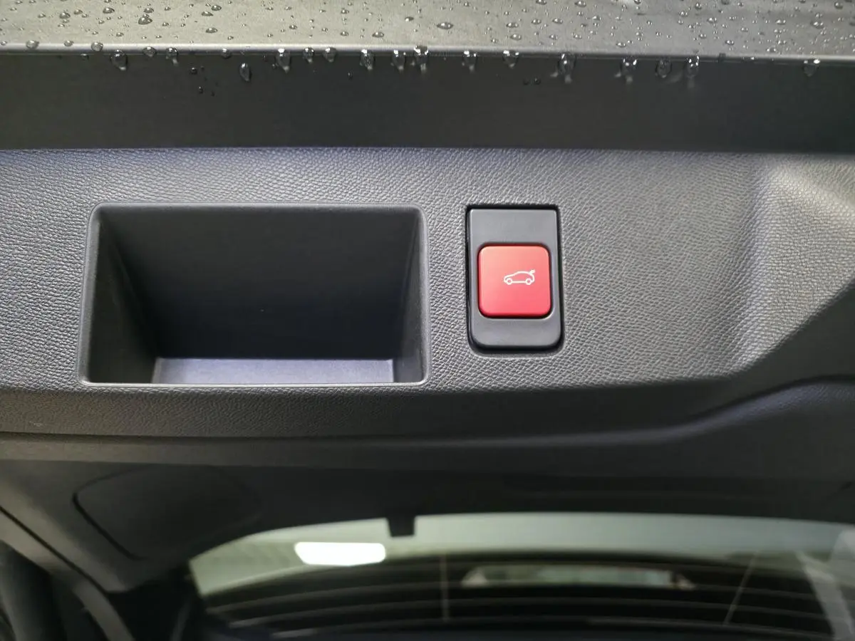 Bouton rouge d'ouverture du hayon mains libres sur la partie intérieure du coffre d'un Citroën C5 Aircross blanc.