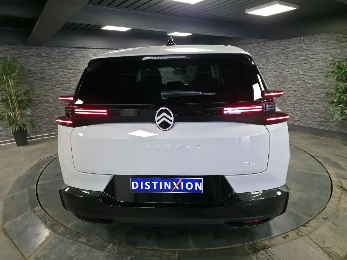 Vue arrière d'un Citroën C5 Aircross blanc avec feux arrière LED horizontaux et logo central noir brillant.