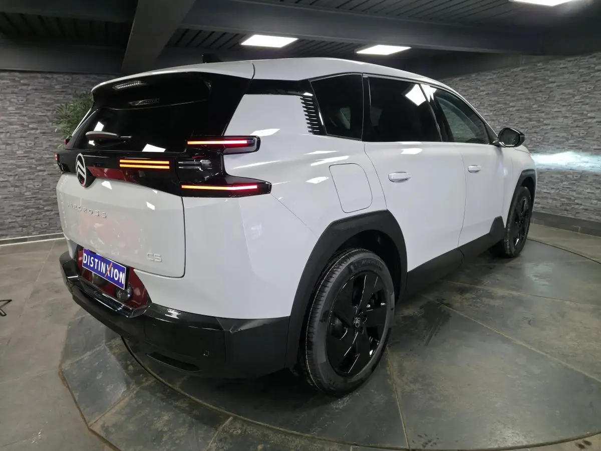 Vue 3/4 arrière droite du Citroën C5 Aircross blanc avec toit noir et feux arrière LED distinctifs.