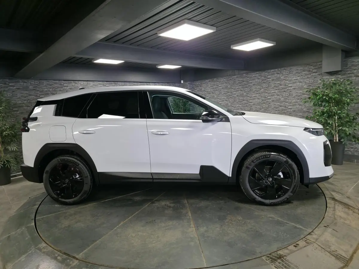 Vue latérale droite du Citroën C5 Aircross blanc avec jantes noires et détails noirs contrastants en intérieur.