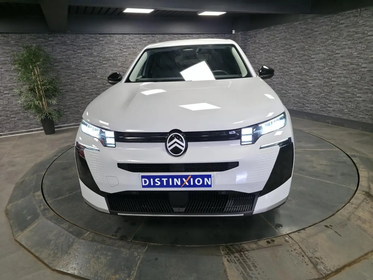 Vue avant d'un Citroën C5 Aircross blanc 2026 avec calandre noire et phares LED allumés en intérieur.