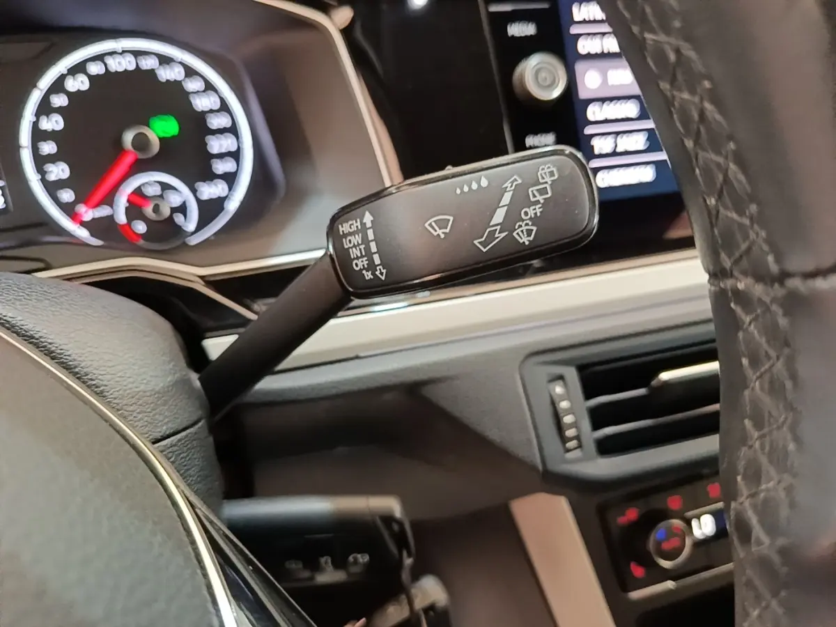 Gros plan sur la manette d’essuie-glace à gauche du volant cuir noir dans l’habitacle d’une Volkswagen Polo 2020.