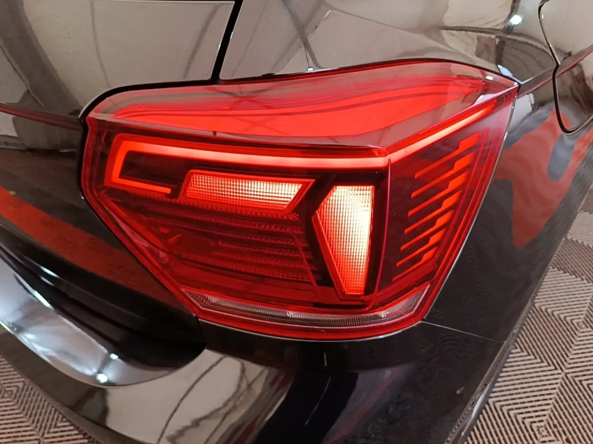 Gros plan sur le feu arrière droit rouge d'une Volkswagen Polo noire, soulignant les lignes modernes du modèle 2020.
