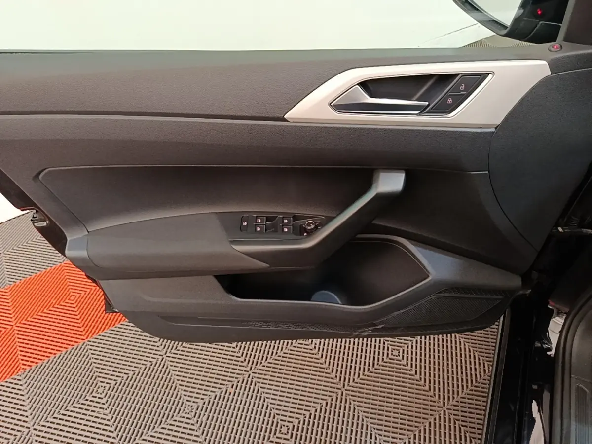 Vue intérieure côté gauche de la porte avant noire d'une Volkswagen Polo 2020 avec commandes de vitres et verrouillage.