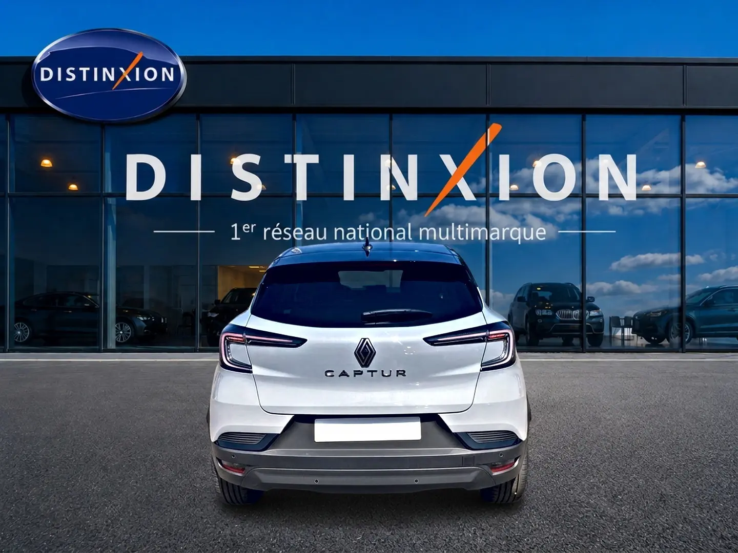 Vue arrière d'un Renault Captur 2026 blanc avec toit noir, feux arrière LED et logo distinctif au centre.