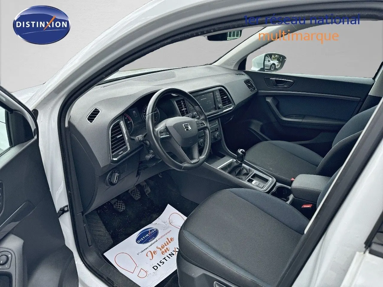 Vue intérieure côté conducteur du SEAT Ateca blanc 2018, montrant le tableau de bord et la boîte manuelle.