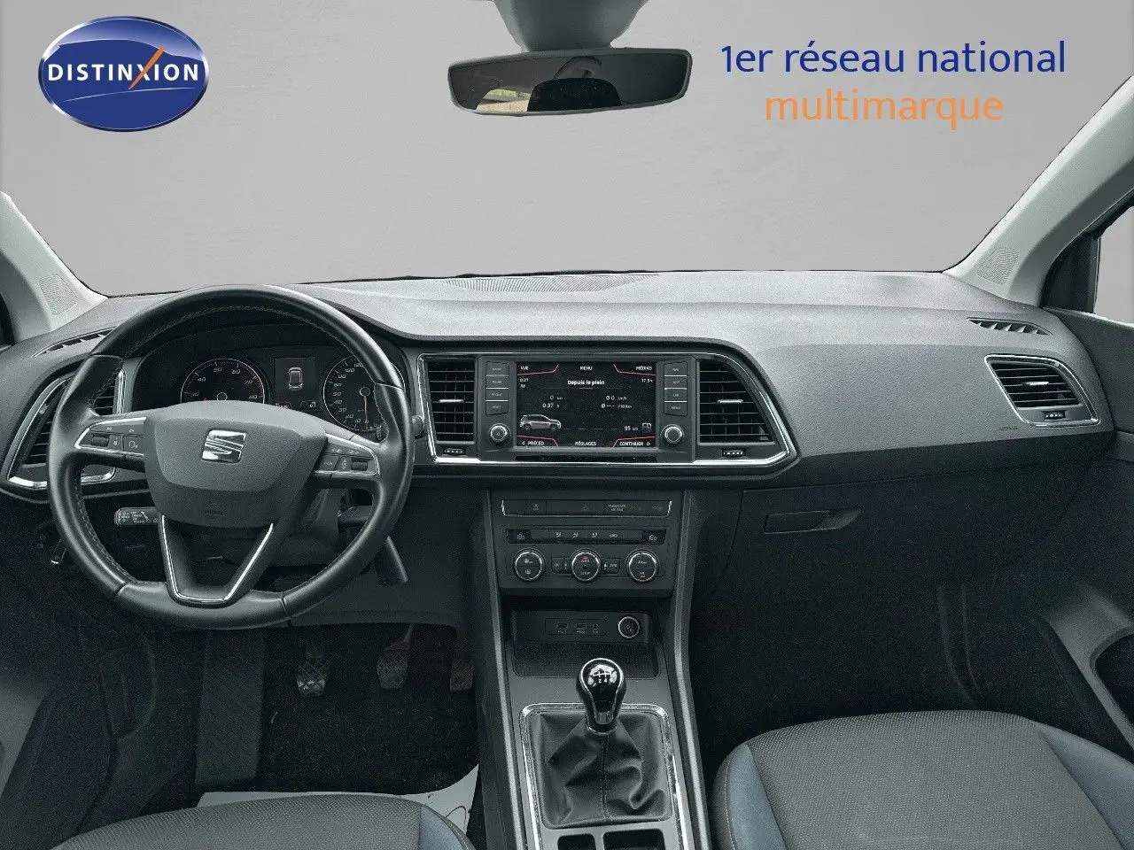 Vue intérieure avant du tableau de bord et volant noir d’un SEAT Ateca 2018 avec boîte manuelle et écran central.