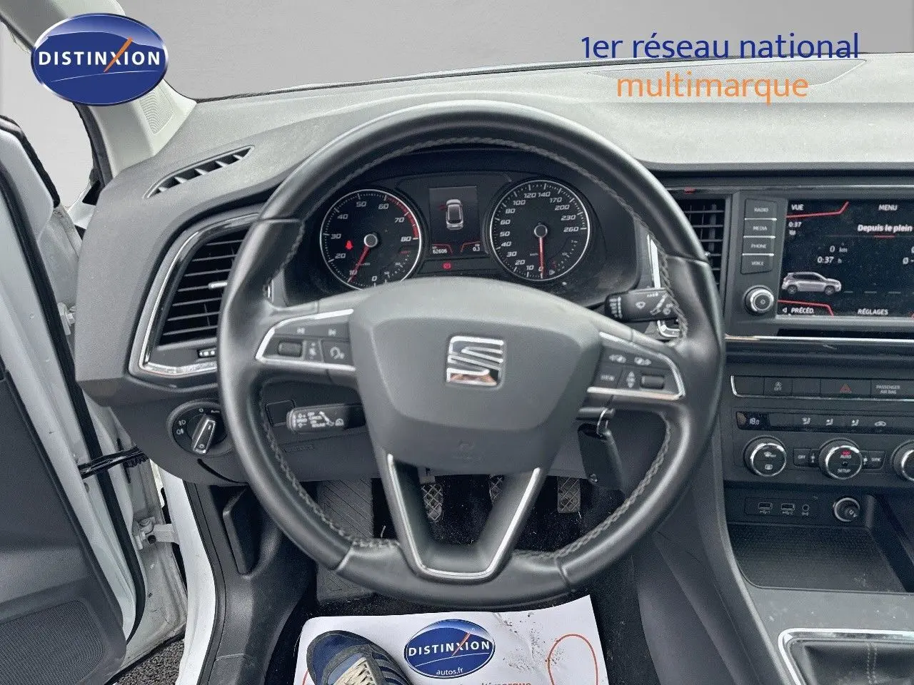 Vue intérieure centrée sur le volant du SEAT Ateca blanc 2018, avec tableau de bord et écran multimédia visibles.