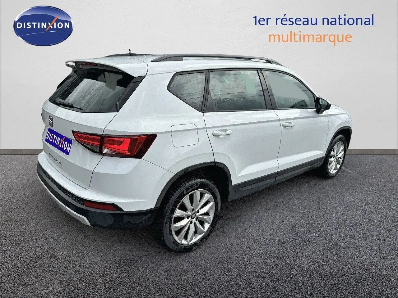 Vue 3/4 arrière droite d’un SUV SEAT Ateca blanc de 2018 avec jantes alliage et toit noir.