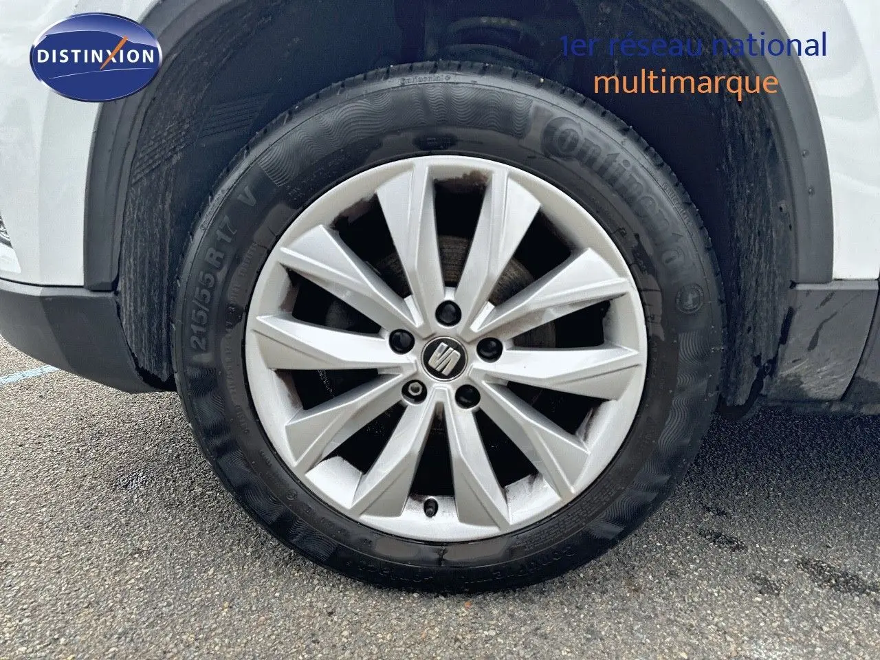 Gros plan sur la roue avant droite d’un SEAT Ateca blanc avec jante alliage à dix branches.