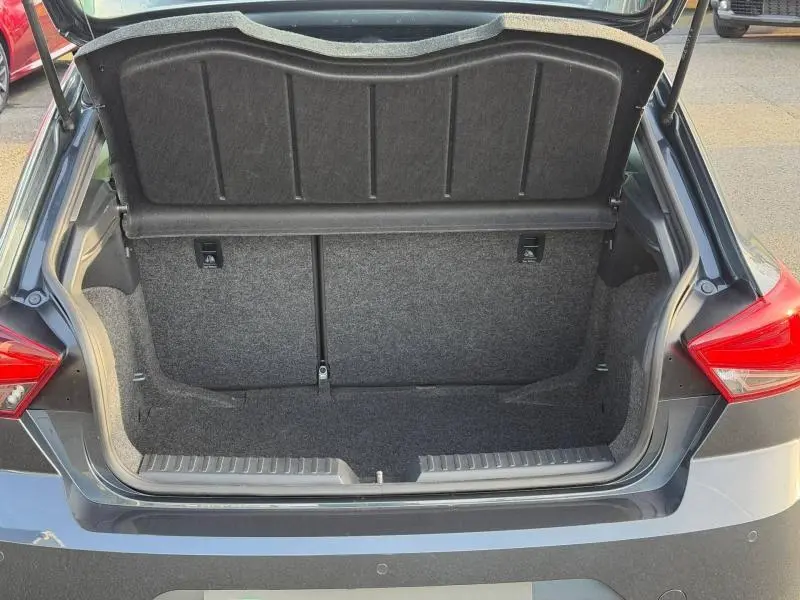 Coffre ouvert vu de l'arrière d'une SEAT Ibiza 2025 gris magnétique métallisé, montrant l'espace de chargement vide.
