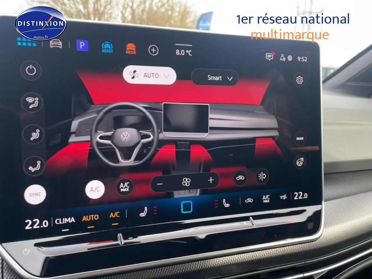 Écran tactile central affichant la console de climatisation et le volant numérique d'une Volkswagen Golf noire, vue de face.