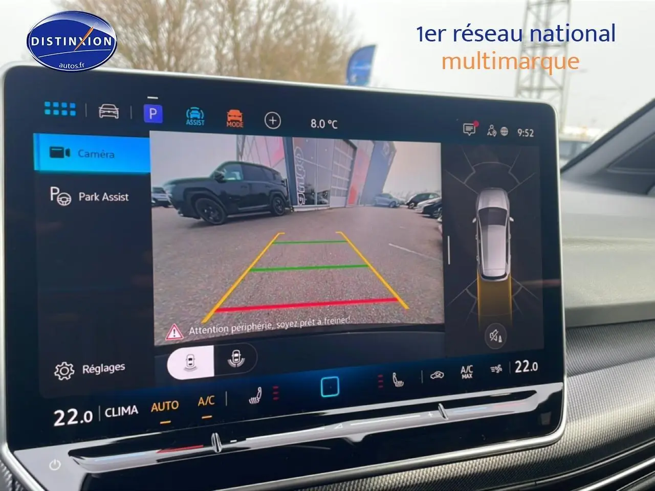 Écran central affichant la caméra de recul et l'aide au stationnement d'une Volkswagen Golf noire, vue arrière.