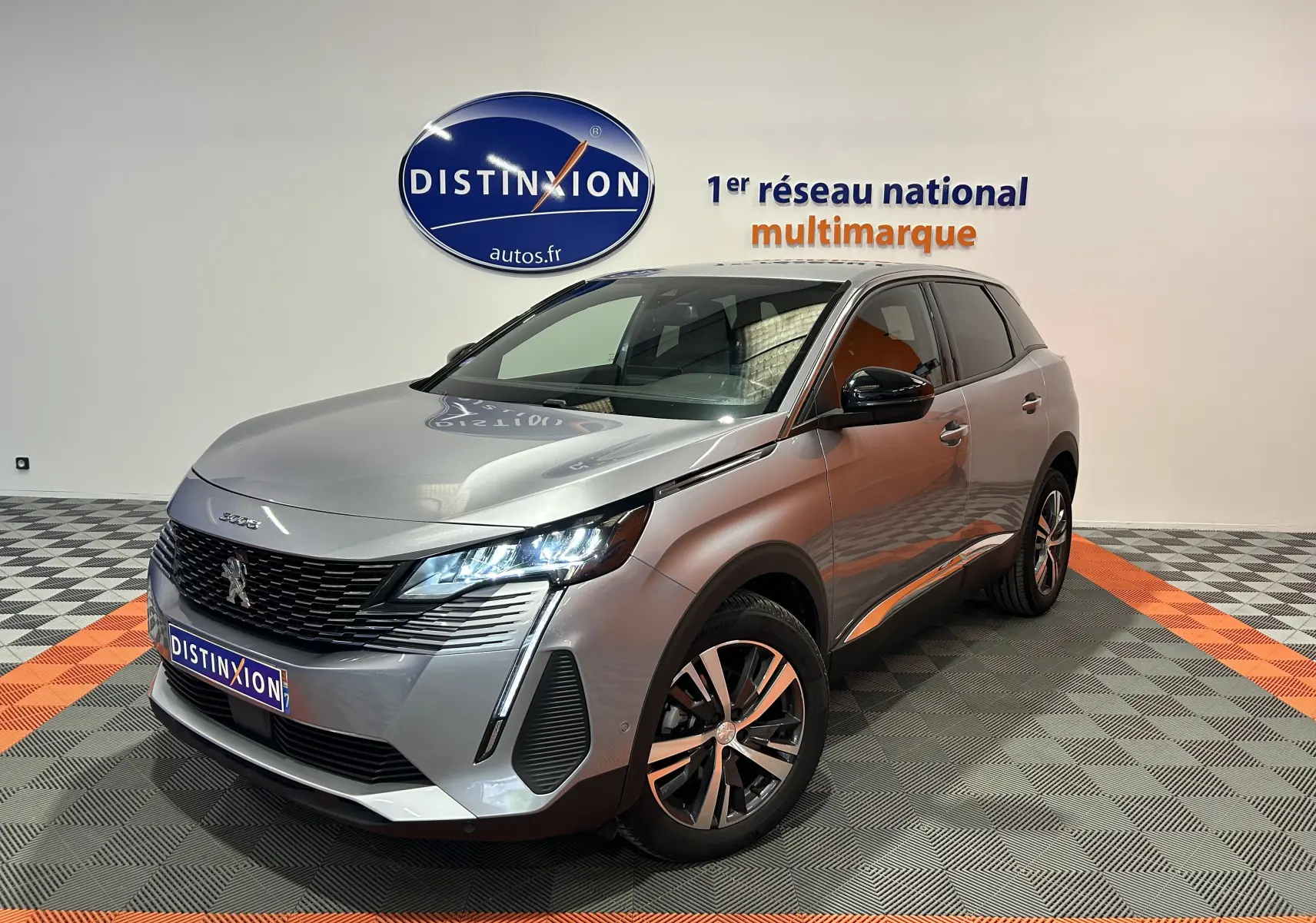 Peugeot 3008 Hybrid gris en 3/4 avant droit, avec phares LED allumés et jantes alliage bicolores.