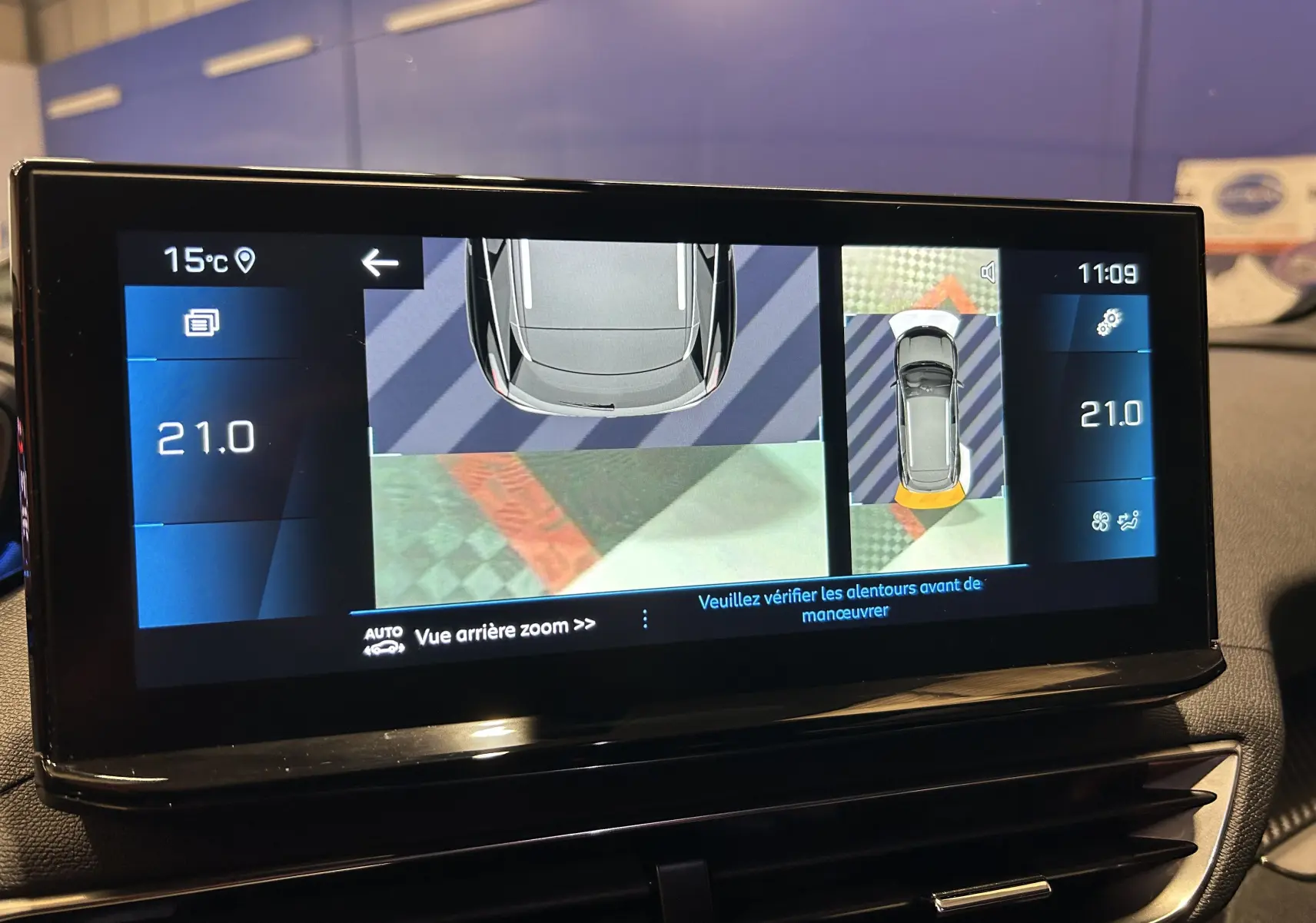 Écran intérieur du Peugeot 3008 Hybrid montrant la caméra 360° avec vue aérienne et zoom arrière, interface digitale.