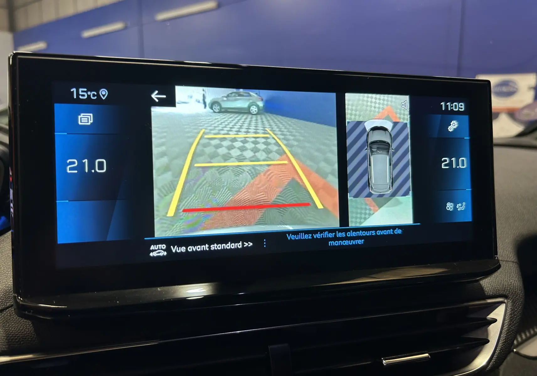 Écran central du Peugeot 3008 Hybrid gris montrant la caméra 360° et la vue avant avec repères de stationnement.