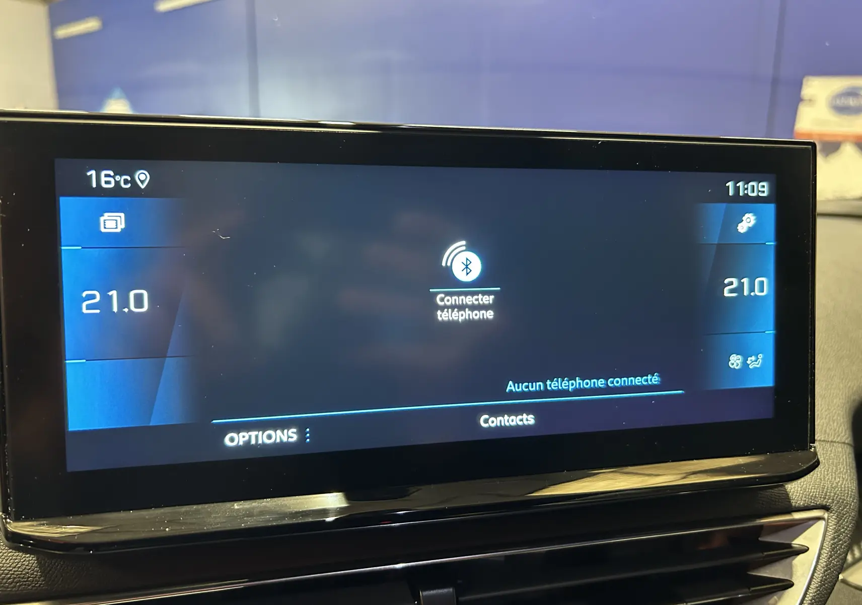Écran tactile central du tableau de bord du Peugeot 3008 gris, affichant la connexion Bluetooth et la climatisation à 21°C.