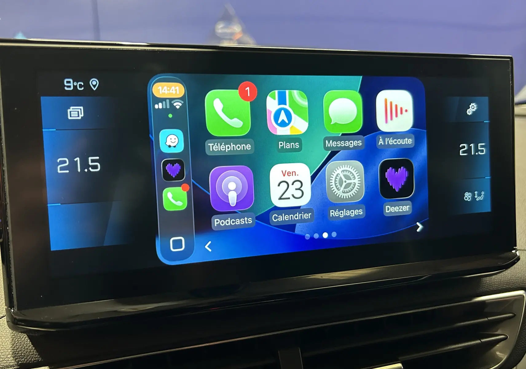 Écran tactile central du Peugeot 3008 Hybrid 2024 affichant les applications smartphone et la climatisation à 21,5°C.