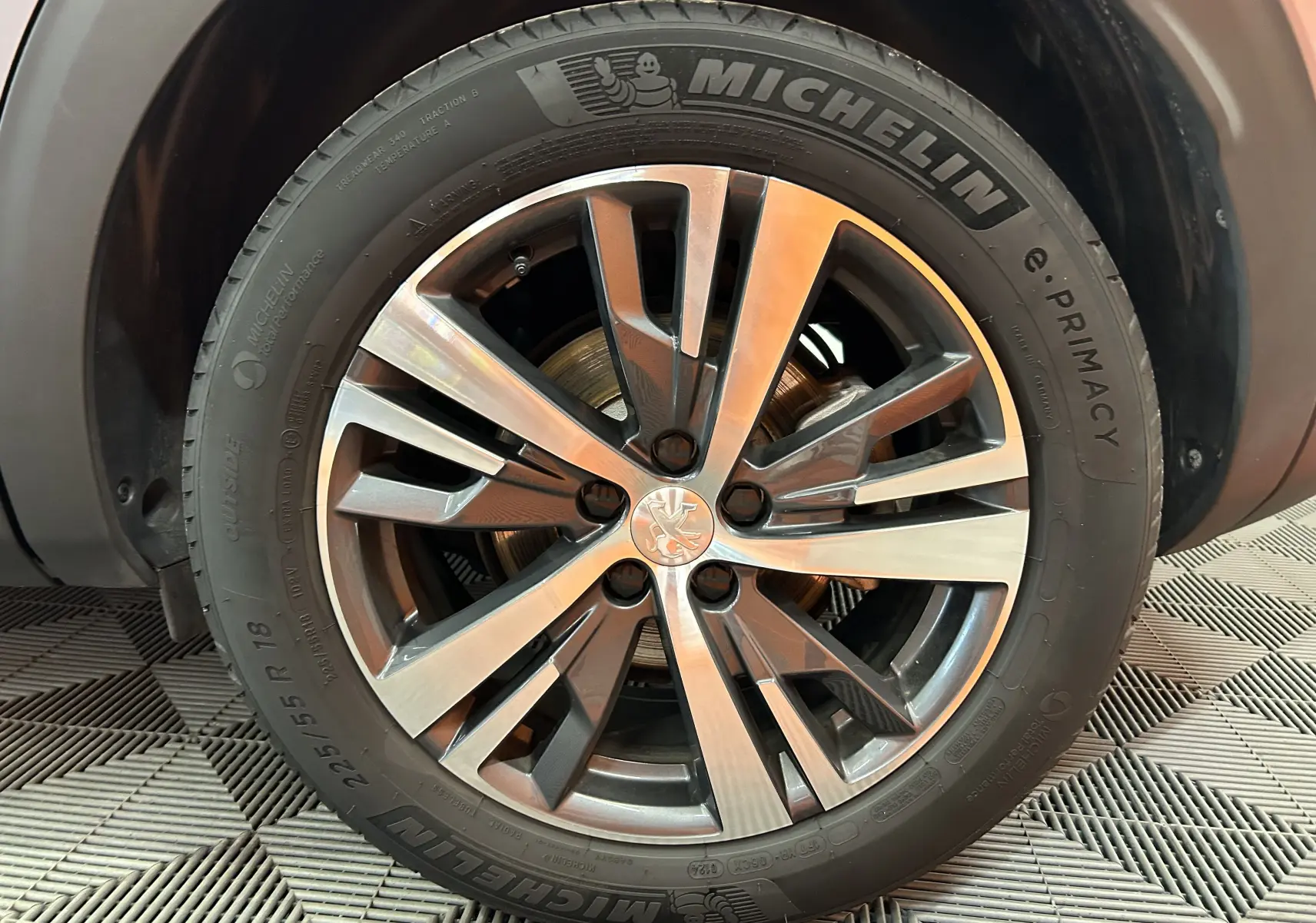 Gros plan sur la roue avant droite du Peugeot 3008 gris 2024, avec jante alliage et pneu Michelin e.Primacy.