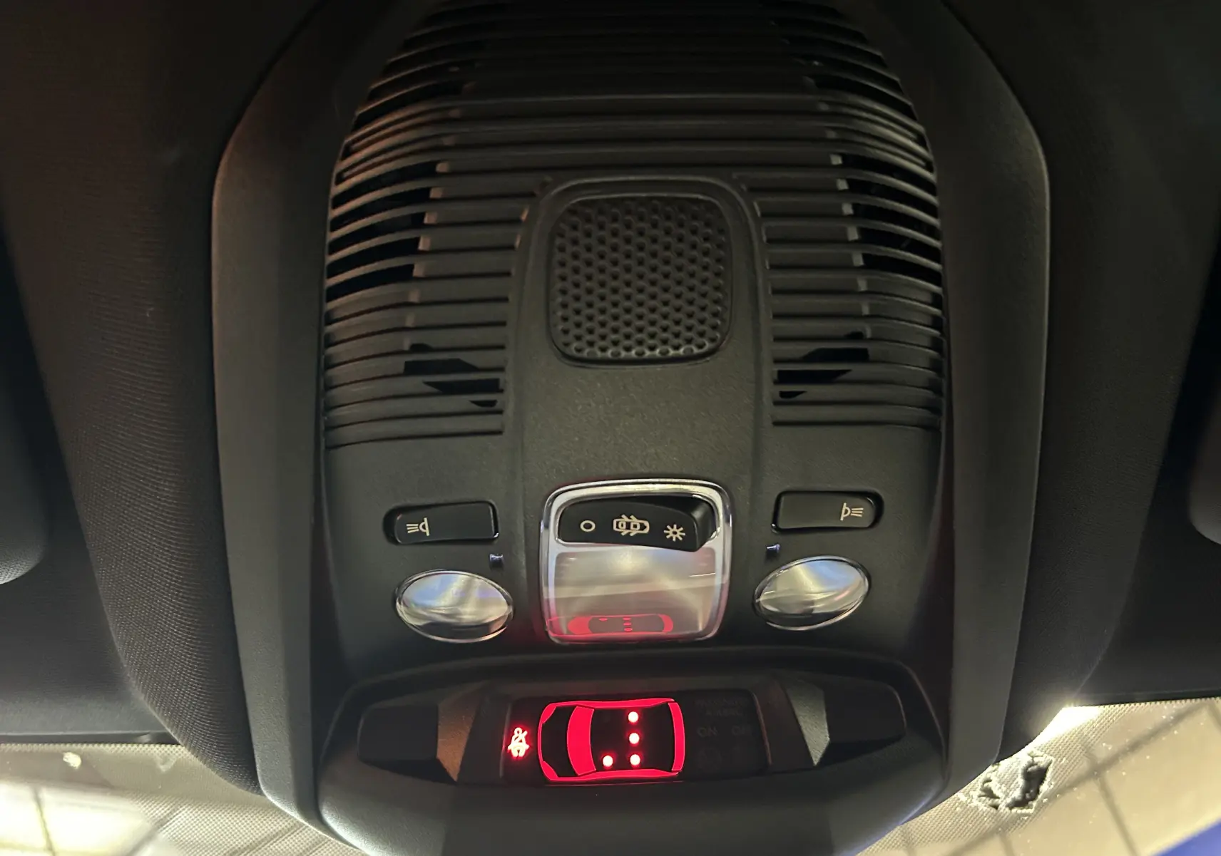 Vue rapprochée du plafonnier intérieur du Peugeot 3008 gris, avec commandes d’éclairage et indicateur de ceinture allumée.