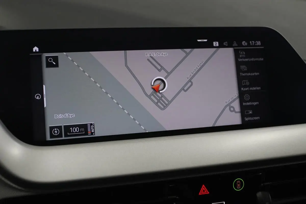 Écran GPS en gros plan dans l’habitacle d’une BMW Série 1 noire, affichant une carte routière détaillée.