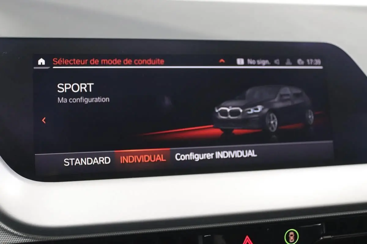 Écran intérieur montrant le mode de conduite SPORT avec illustration d'une BMW Série 1 noire en vue 3/4 avant.