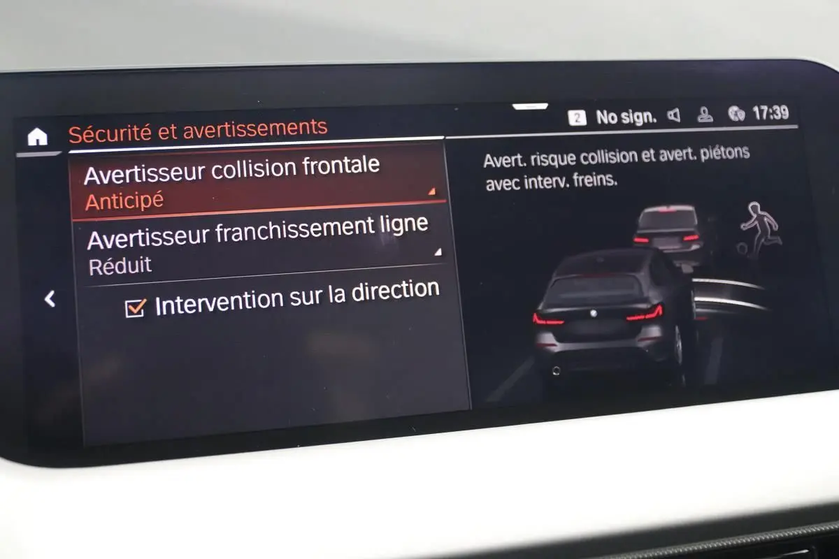 Écran intérieur de la BMW Série 1 116d noir montrant les réglages d'avertissement collision et franchissement de ligne.