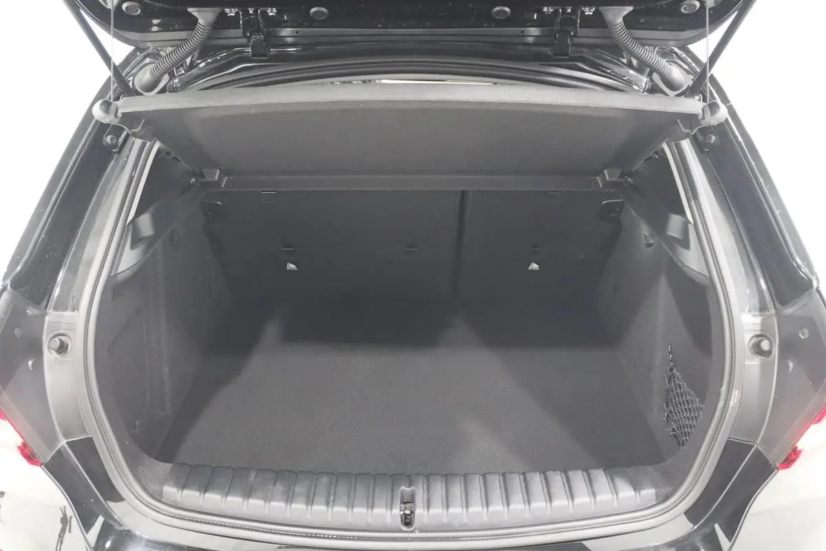 Coffre ouvert vu de l'arrière d'une BMW Série 1 noire 116d 2023, espace de chargement vide et propre.