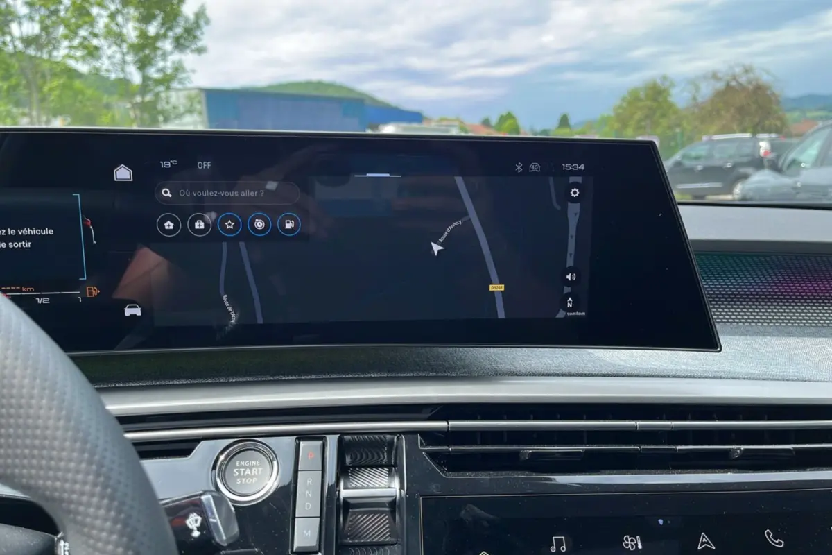 Vue intérieure du tableau de bord du Peugeot 5008 Hybrid 145 GT, écran tactile central avec navigation affichée.