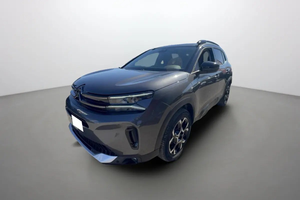 SUV Citroën C5 Aircross gris platinium en 3/4 avant droit avec jantes alu et barres de toit visibles.