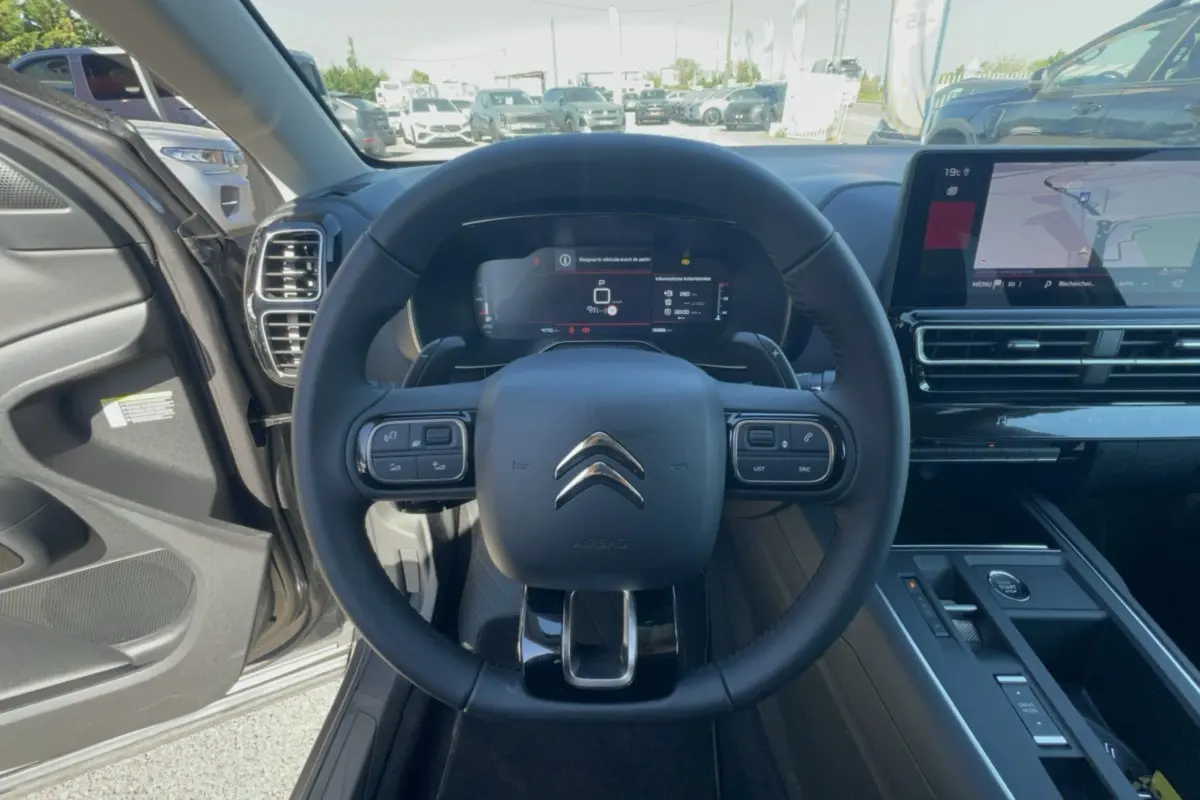 Vue intérieure centrée sur le volant cuir multifonctions du Citroën C5 Aircross 2025 avec écran digital et console moderne.