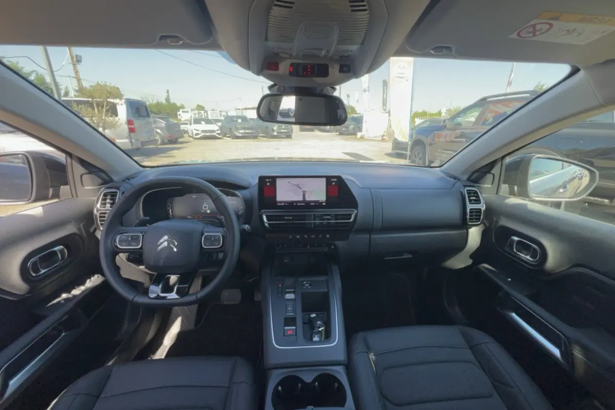 Vue intérieure avant du Citroën C5 Aircross gris platinium, volant multifonctions et écran tactile central avec navigation.