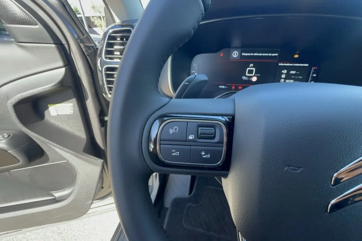 Gros plan sur le volant cuir multifonctions côté gauche du Citroën C5 Aircross 2025, intérieur gris platinium.