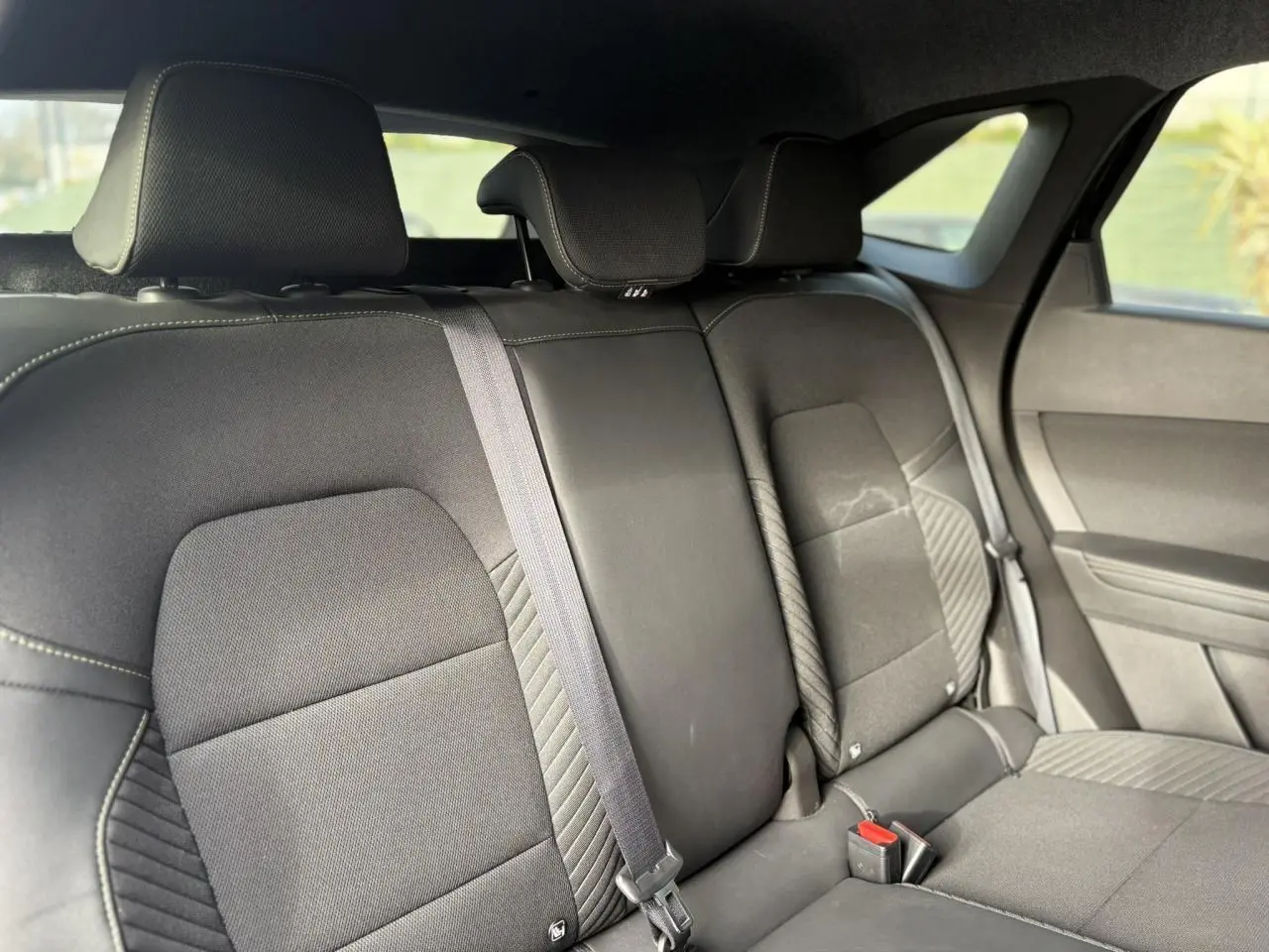 Vue intérieure sur la banquette arrière noire du Renault Symbioz 2025, avec appuie-têtes et ceintures visibles.