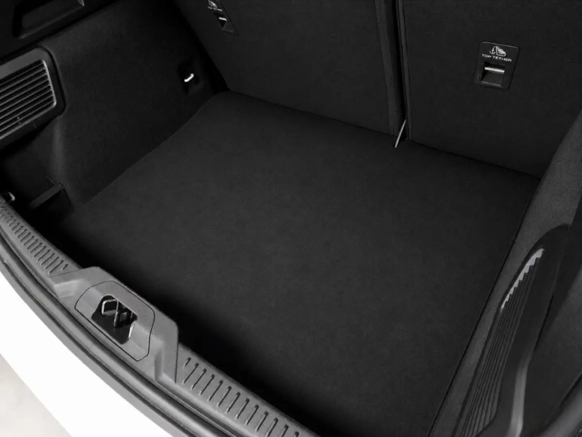 Vue du coffre ouvert d'une Ford Focus blanche 2024, mettant en valeur l'espace de chargement noir et les finitions intérieures.