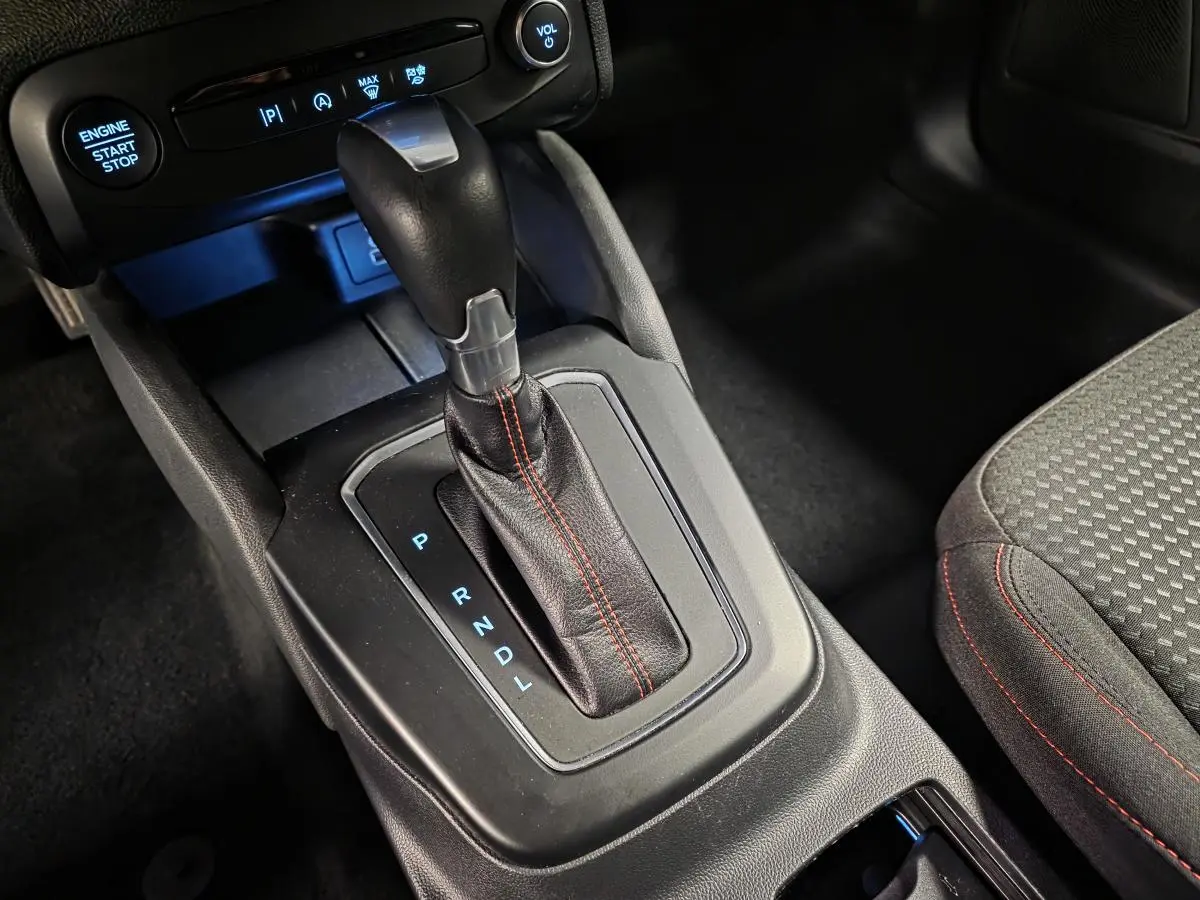 Gros plan sur le levier de vitesses automatique en cuir noir avec surpiqûres rouges de la Ford Focus ST Line 2024.