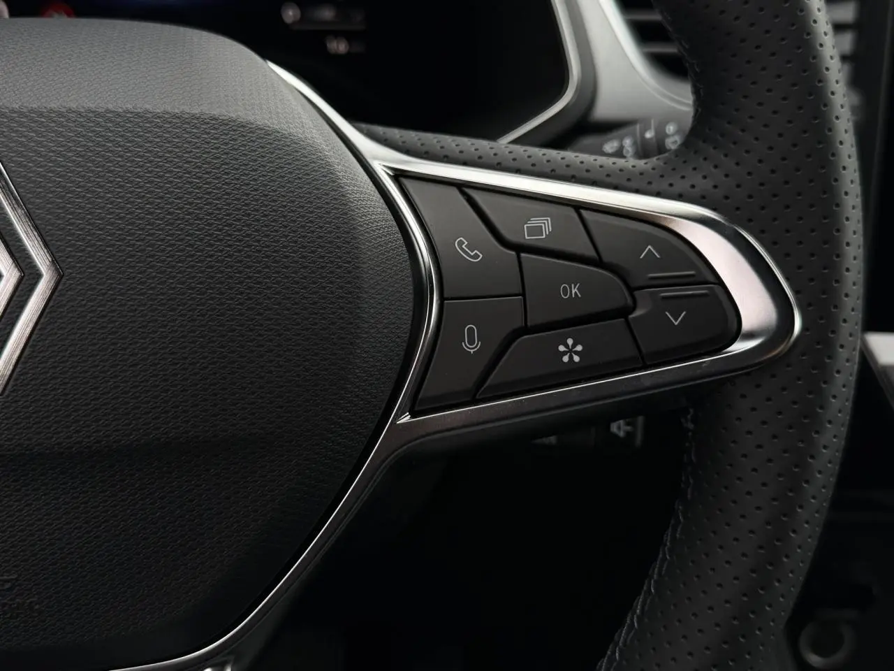 Gros plan sur le côté droit du volant perforé du Renault Captur 2026 avec commandes multifonctions intégrées.