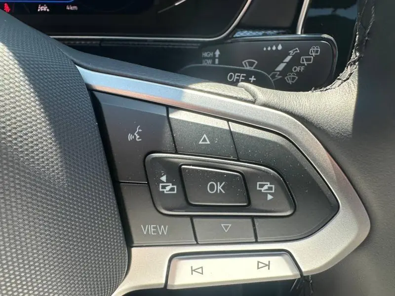 Gros plan sur les commandes multifonctions du volant cuir noir du Volkswagen T-Cross 2026, finition R-Line.