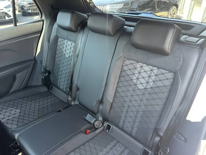 Vue intérieure de la banquette arrière du Volkswagen T-Cross 2026, tissu R-Line gris avec motifs géométriques.