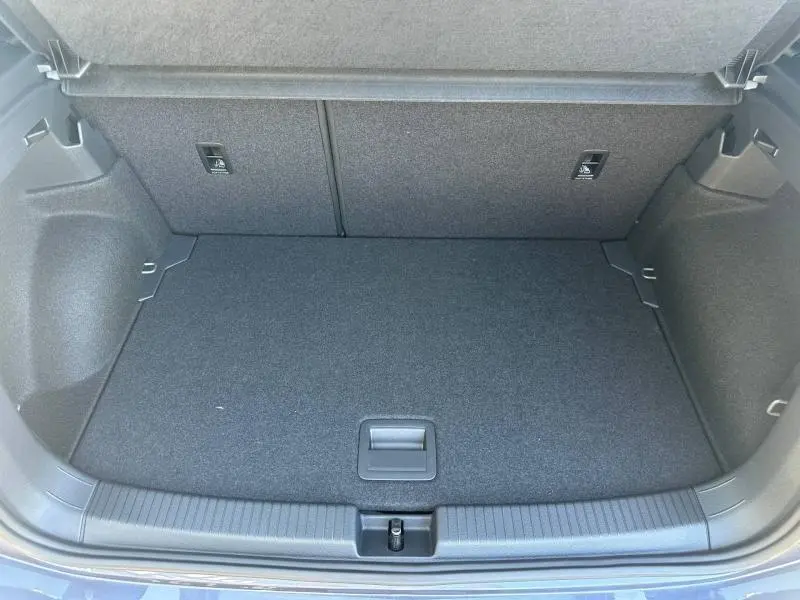 Coffre ouvert vu de face du Volkswagen T-Cross gris cendré, montrant un espace de chargement propre et bien fini.