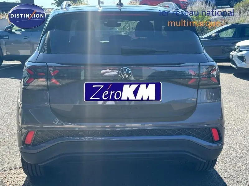 Vue arrière d'un Volkswagen T-Cross gris cendré métallisé avec feux arrière LED et logo VW centré.
