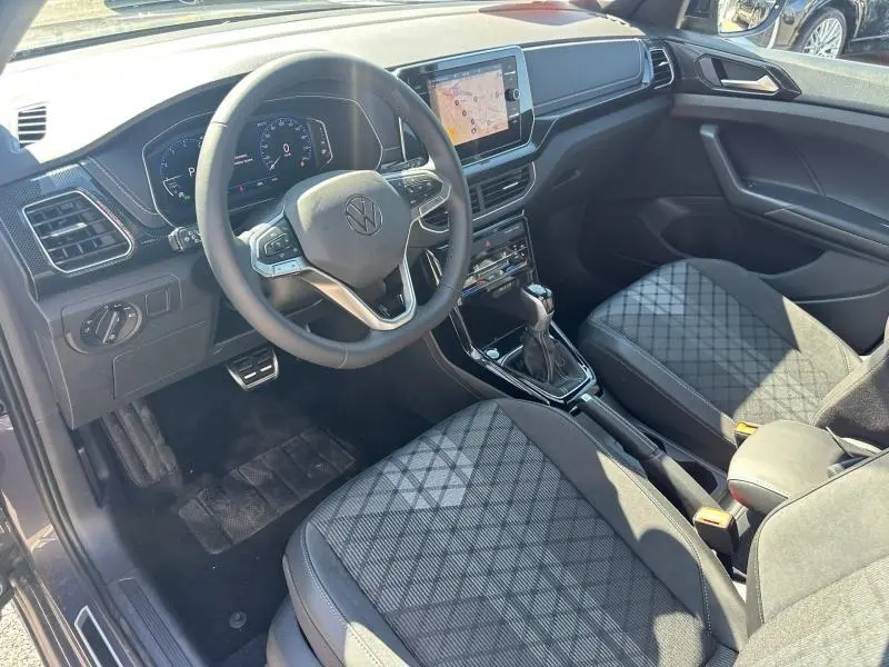 Vue intérieure côté conducteur du Volkswagen T-Cross 2026, volant cuir multifonction et sièges tissu R-Line gris/noir.