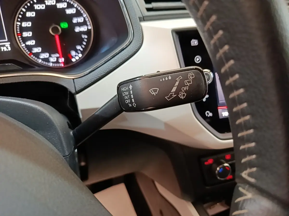 Gros plan sur la commande d’essuie-glace à gauche du volant dans l’habitacle gris clair du SEAT Arona 2019.